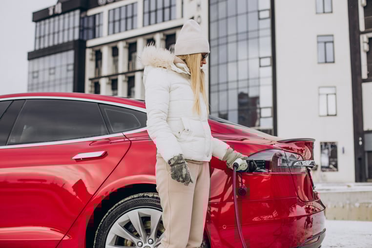 woman-charging-red-electro-car-winter-time