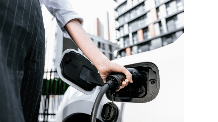 woman charging her EV wearing office clothes